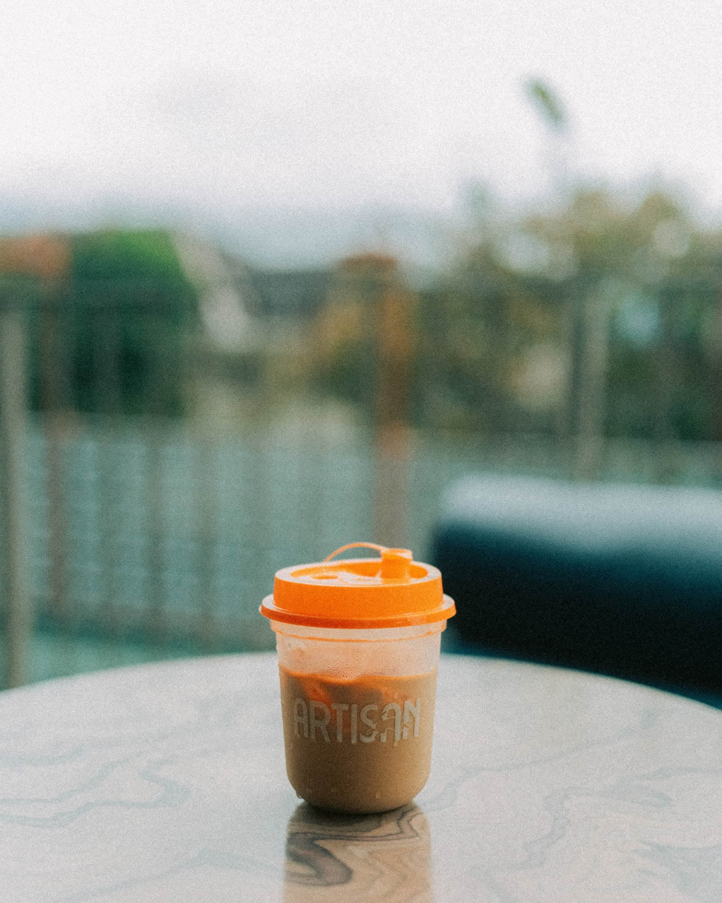 An Artisan coffee on a table with the pool behind